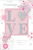 This anniversary card is depicted with a softness that mirrors the gentle tone of an intimate celebration in Camden. In the middle, the word LOVE is raised from the surface in rounded letters coated with shimmering glitter, giving a tactile, almost velvety feel when imagined under the fingertips. The glitter reflects subtle hints of silver, standing out delicately against a backdrop of blush pink that forms a central panel, transitioning outward into a smooth field of pearlescent white and very light grey. Flowing around this highlighted centre, fine-line illustrations of stylised flowers and slender leaves weave in sweeping arcs, their shapes reminiscent of stems and petals arranged by an attentive florist. The blossoms appear in shades of blush, muted mauve, and soft grey, with delicate silver-like accents catching the imaginary light, much like foil details. These floral and leafy swirls provide a sense of movement and airy grace, framing the raised LOVE as though cradling it. Nestled among the designs, an elegant script carries heartfelt anniversary messages, its cursive lines harmonising with the looping vines and gentle curves. The design leaves open spaces where the background's soft sheen shows through, preventing the card from feeling crowded and reinforcing its dreamy, romantic quality. The whole impression evokes the mood of sharing an evening indoors after flowers have been delivered across Camden-quiet, warm, and deeply personal, like a bouquet translated into soft colour and line on paper.